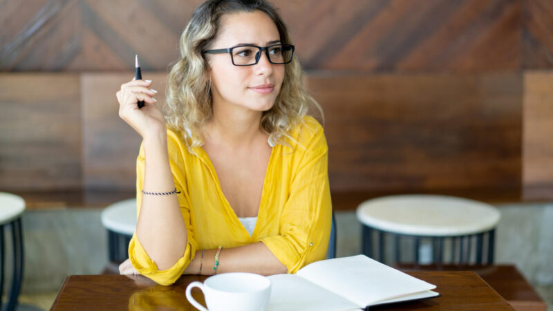 pretty-curly-young-woman-writing-notes-startup-project